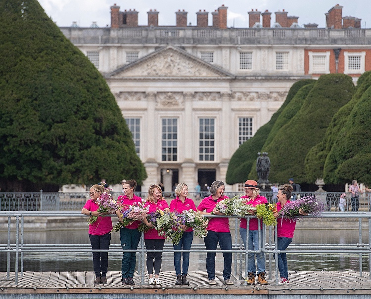 Flower School at RHS Hampton Court will feature flower farmer florists - here the FFTF team line up in their pink shirts clutching armfuls of beautiful British cut flowers in front of the Hampton Court facade.