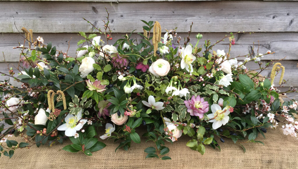 A natural casket spray with spring flowers and catkins. Funeral flowers by Gabriel's Garden