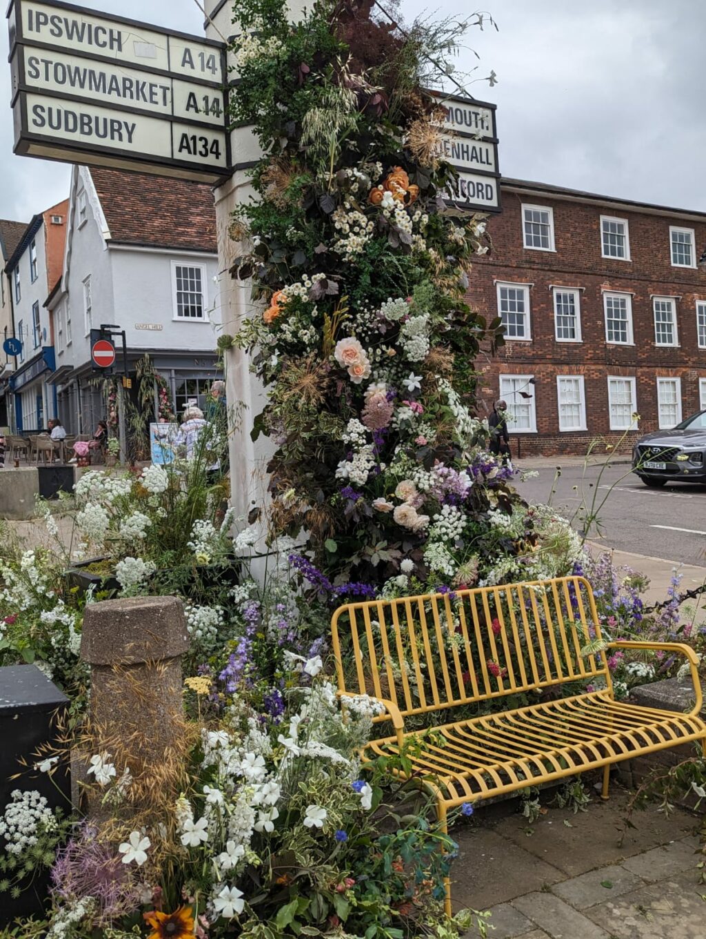 A local signpost in Bury St Edmunds, Suffolk decorated with british flowers by members of Flowers from the Farm for British Flowers Week 2023