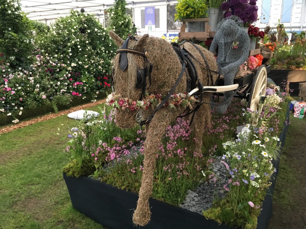Flora the straw horse strides out at RHS Chelsea on FFTF's Going to Market display, pulling a flower laden cart along a meadow path.