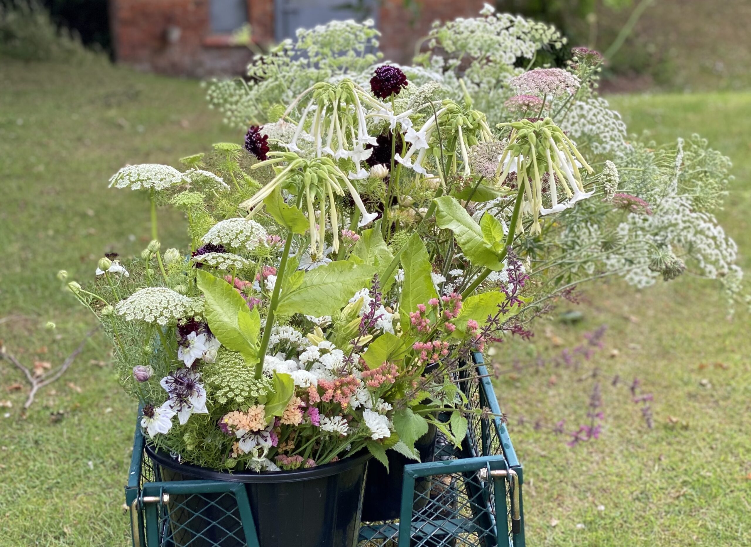 A flower trolley overflowing with cool greens and whites at Smellanie's Garden Flowers